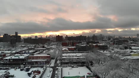 Combing-the-rooftops-of-Brooklyn,-NY's-East-Williamsburg,-this-aerial-shot-explores-the-skies-right-after-a-large-snow-storm