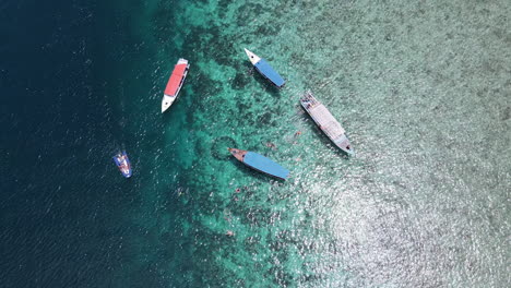 Barcos-Turísticos-En-La-Laguna-Azul-Brillante-En-Bali,-Indonesia-Con-Gente-Buceando-En-Verano