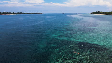 Aerial-View-Of-Tourists-Swimming-At-The-Blue-Ocean-Of-Bali-Sea-In-Indonesia