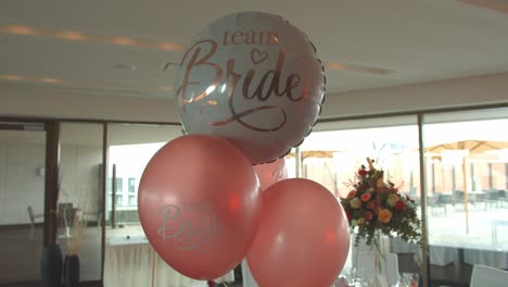 White-and-pink-helium-balloons-of-bride-team,-interior-shot