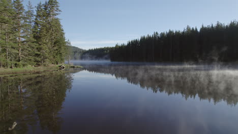 Ruhiger-Nebliger-See-Mit-Spiegelungen-Im-Wasser