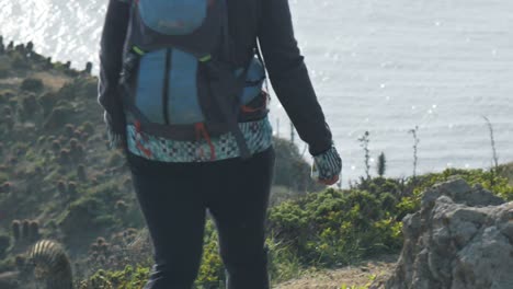Girl-hiking-on-a-high-cliff-near-the-ocean