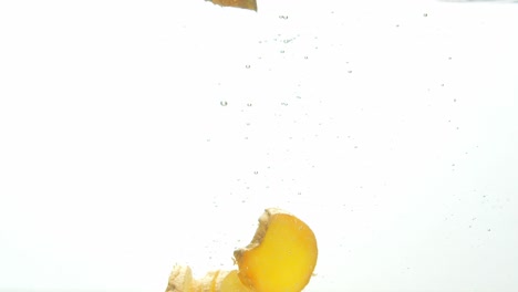 Fresh-ginger-dropped-into-water,-isolated-on-white-background