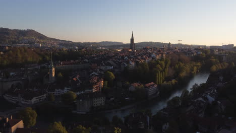 Slow-rise-downward-tilt-area-shot-above-Bern,-Switzerland-at-sunset
