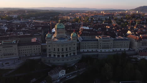 Aerial-subject-rotate-shot-of-the-Parliament-building-in-Bern,-Switzerland-at-sunset