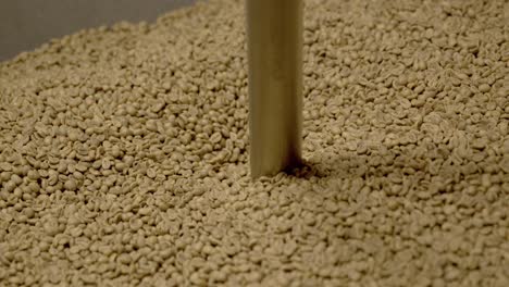 Industrial-coffee-machine-with-raw-beans-inside-falling-in,-close-up-slow-motion-shot