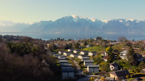 Drone's-flight-over-the-Leman-Lake-from-Montreux's-district,-featuring-the-the-French-border-and-aiming-at-the-mountains