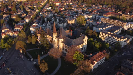 Slow-aerial-orbit-shot-of-a-large-school-in-Bern,-Switzerland-at-sunset