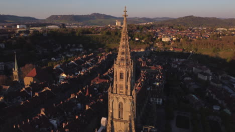 Aerial-rotate-and-reverse-shot-of-the-Bern-Cathedral-in-Switzerland-at-golden-hour