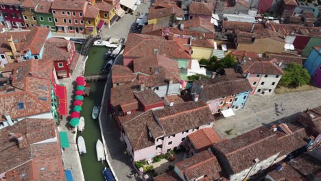 Drohnenflug-In-Geringerer-Höhe-Nach-Links-über-Burano-Venedig-Italien-Hinaus-Auf-Die-Offene-Lagune-Mit-Bunten-Häusern,-Kanälen-Und-Booten