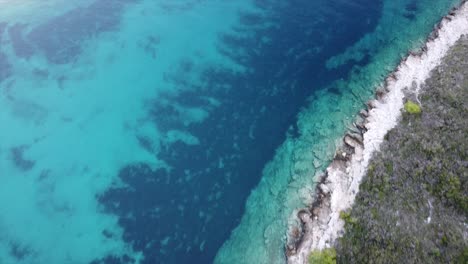 Amazing-deep-colors-of-an-aerial-drone-shot-camera-faced-down-of-crystal-clear-ocean-waters-in-a-cove-in-Croatia