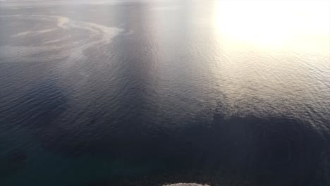 Aerial-view-on-open-ocean-from-drone-early-morning-onto-an-island-with-oil-spill-on-surface-of-water-in-Europe