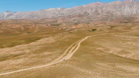 Ansicht-Des-Reisenden-Fahrzeugs-Auf-Unebenen-Wüstenstraßen-In-Arashan-seen,-Namangan,-Ferghana-tal,-Usbekistan