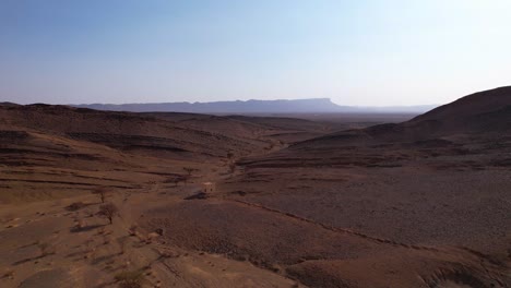 Filmischer-Luftflug-über-Die-Marokkanische-Sahara-wüste-Mit-Sanddünen-Und-Getrockneten-Feldern-An-Einem-Sonnigen-Tag-In-Marokko,-Afrika