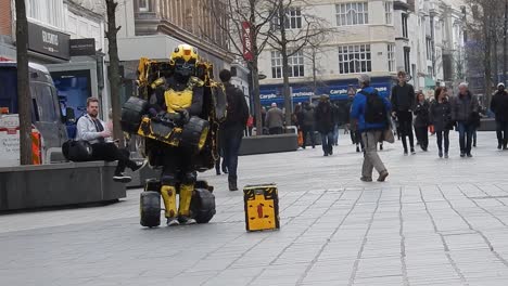 Hombre-No-Identificado-Disfrazado-De-Robot-Abejorro-Realiza-Una-Actuación-Callejera-De-Transformadores-En-El-Ajetreado-Centro-De-La-Ciudad