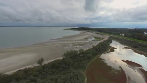 Aerial:-Nature-reserve-next-to-a-cargo-port-in-Vlissingen,-the-Netherlands