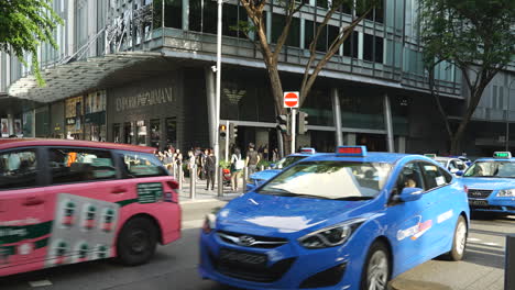 Singapur---Ca.-Zeitraffer-Menschenmassen-Rasen-über-Den-Zebrastreifen,-Während-Der-Verkehr-Stoppt-Und-Auf-Der-Orchard-Road-Singapur-Weiterfährt