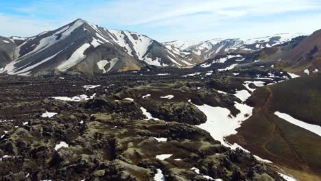 Black-lava-field-with-patches-of-white-snow-in-the-ravine-of-rainbow-mountains-of-Landmannalaugar-in-Iceland