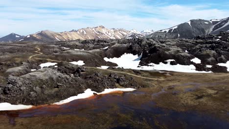 Spectacular-hiking-trail-across-magma-field-and-snow-in-rainbow-mountains-of-Landmannalaugar-in-Iceland