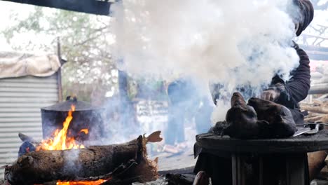 Local-South-African-woman-using-a-red-hot-iron-to-scorch-wool-off-a-sheep's-head-in-the-township-of-Langa,-Cape-Town