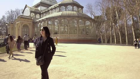 Glückliche-Touristin-In-Madrid,-Schlendern-Sie-Vor-Dem-Palacio-De-Cristal-Im-Retiro-Park,-Madrid