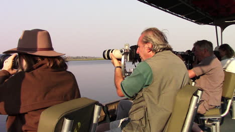Fotografen,-Die-Im-Sommer-Afrikanische-Wildtiere-Auf-Dem-Chobe-Fluss-Von-Einem-Speziellen-Fotoboot-Aus-In-Sehr-Niedrigen-Winkeln-Und-In-Unmittelbarer-Nähe-Der-Wildtiere-Fotografieren