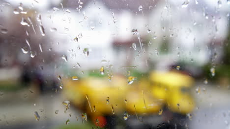 Rain-drops-on-a-window-overlooking-a-road-with-passing-truck
