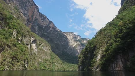 Boat-sailing-the-Grijalva-river-between-the-huge-cliffs-of-the-Sumidero-Canyon,-Chiapas-Mexico