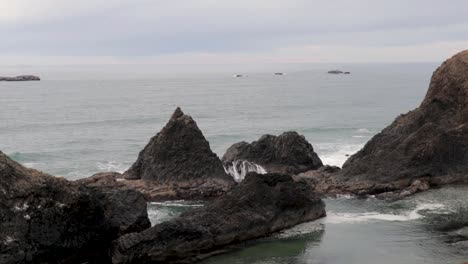 Eine-Welle,-Die-Zwischen-Zwei-Felsen-An-Der-Pazifikküste-Plätschert