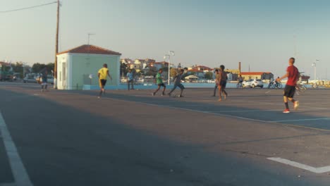 Weite-Aufnahme-Von-Flüchtlingen,-Die-Auf-Einem-Betonparkplatz-Fußball-Spielen