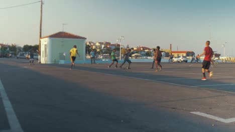 Plano-General-De-Refugiados-Jugando-Fútbol-En-Un-Estacionamiento-De-Concreto