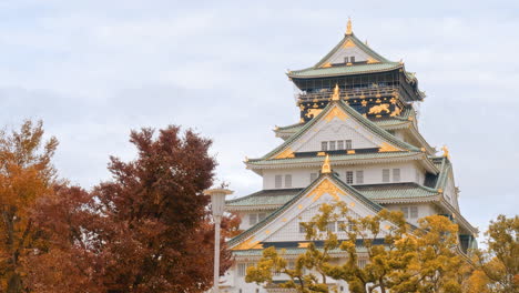 Detail-of-Osaka-Castle-Japan,-autumn-fall-color-trees-foreground