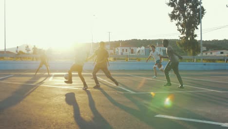 Flüchtlinge-Spielen-Bei-Sonnenuntergang-Auf-Einem-Asphaltfeld-Fußball