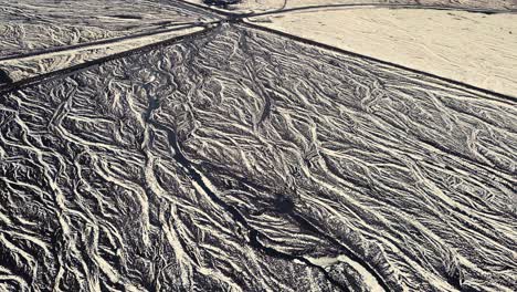 Drone-showing-beautiful-patterns-in-the-landscape-below,-on-snowy-conditions