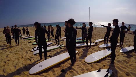 Young-people-on-a-begginer-surf-class-following-instructions