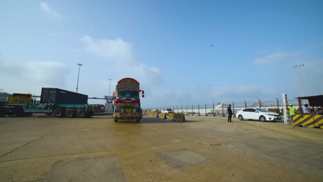 Trucks-entering-into-the-port,-A-long-vehicle-traller-is-moving-on-the-road-of-a-port,-camera-passing,-close-up-view