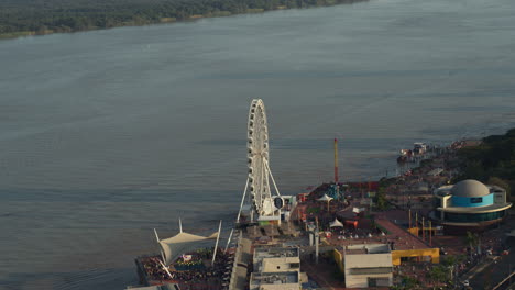 La-Perla-Ferris-Wheel,-Aerial-Travelling-Out-Malecon-Guayaquil-City-Ecuador