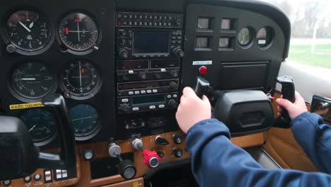 Little-child-playing-pilot-in-the-cabin-of-light-sport-aircraft,-childhood-dreams-of-flying,-closeup-of-instrument-panel-and-moving-the-controls