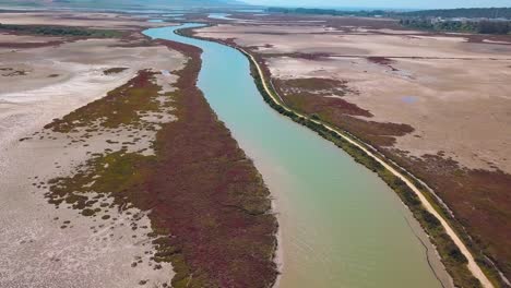 Aerial-shot-of-the-Barbate-river-in-Cadiz-surrounded-by-marshes-near-the-coast