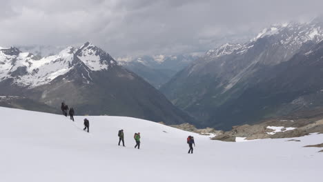 Men-Hiking-along-snow-trail-at-Zermatt-Matterhorn-Glacier-Landscape