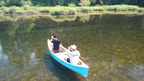 Reveal-shot-of-two-men-canoeing-on-a-lake