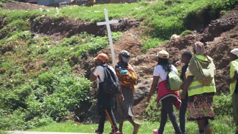 A-group-of-African-spiritual-pilgrims-carry-a-large-wooden-cross-while-walking-on-a-busy-highway