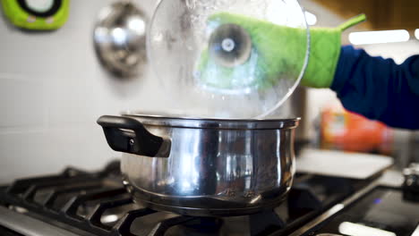 Steam-releasing-from-a-boiling-pot-on-the-stove-in-a-kitchen