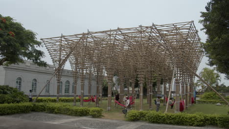 People-relaxing-at-a-wooden-installation-with-hammocks-in-the-park-area-on-top-of-Mount-Fortress-in-Macau,-Macau-SAR,-China