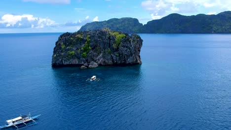 Wide-aerial-shot-of-dive-boat-at-North-rock-dive-site,-El-Nido,-Palawan,-Philippines