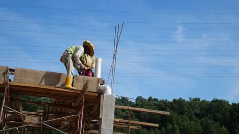 Bauarbeiter,-Die-Auf-Der-Baustelle-Holzschalungen-Und-Regenwasserrohre-Installieren