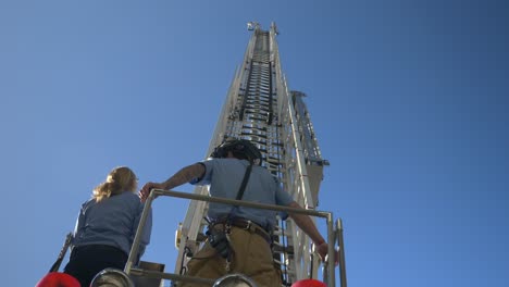 Operador-De-Bomberos-Una-Larga-Escalera-De-Rescate-En-La-Parte-Superior-De-Un-Camión-De-Bomberos