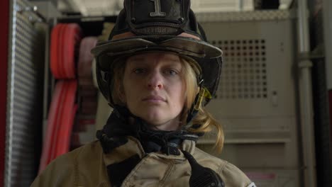 Weiblicher-Feuerwehrmann-In-Schutzhelm-Und-Feuerwehrmantel-Schaut-In-Die-Kamera