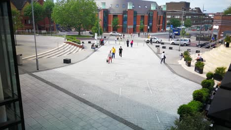 Fußgänger,-Die-über-Den-Gehweg-Gehen,-Der-Vom-Stadtzentrum-Von-Swindon-Zum-Regent-Circus-Führt,-Mit-Blick-Auf-Die-örtlichen-Busse-Und-Die-Bibliothek-Im-Hintergrund