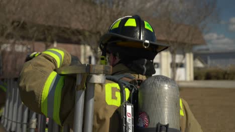 Firefighters-carry-a-rescue-ladder-to-a-building